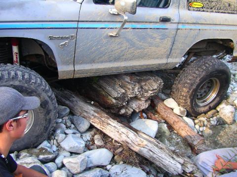 1984 Ford Bronco II - This lifted Ford Bronco II navigates a rocky obstacle course, its tires straddling fallen logs.