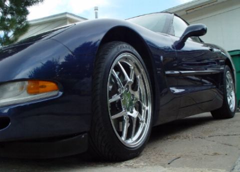 2001 Chevrolet Corvette - A dark blue 2001 Chevrolet Corvette is shown from a low angle, highlighting its design and chrome wheels.