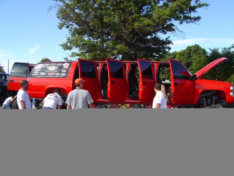 1978 Ford Bronco - This heavily modified red pickup truck has been stretched into a limousine with six doors on one side.