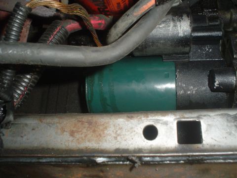 1993 Ford Taurus - Close-up view of a starter motor assembly, a green protective cap and various electrical wires.