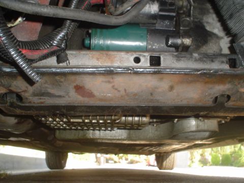 1993 Ford Taurus - Underside view of a car's starter motor and wiring harness, showing engine components.