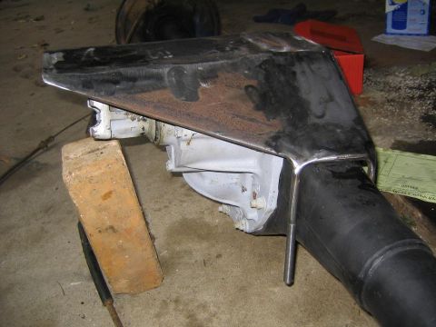 1978 Ford Bronco - A custom skid plate is attached to the lower unit of a boat's drive system, supported by wooden blocks.