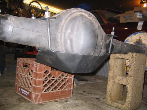 1978 Ford Bronco - Rear differential assembly, likely from a truck or SUV, is shown supported by a milk crate and cinder block in a garage setting.