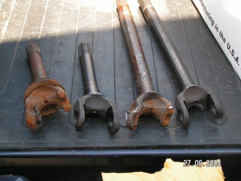 1978 Ford Bronco - A collection of driveshaft components, some showing significant rust, are displayed on a dark surface.