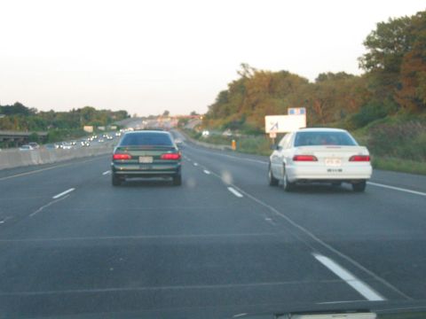 1993 Ford Taurus - Two Ford Taurus sedans are seen driving on a highway during the day.