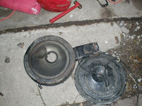 1979 Ford Bronco II - This photo shows a disassembled air cleaner assembly lying on a concrete surface.