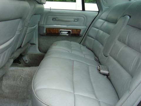 1985 Mercury Grand Marquis - Rear interior view of a 1985 Mercury Grand Marquis, highlighting the quilted leather seats and wood trim.