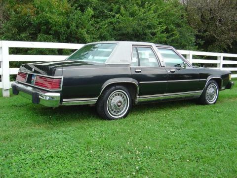 1985 Mercury Grand Marquis - This 1985 Mercury Grand Marquis is shown from its rear three-quarter view, parked on a grassy lawn.