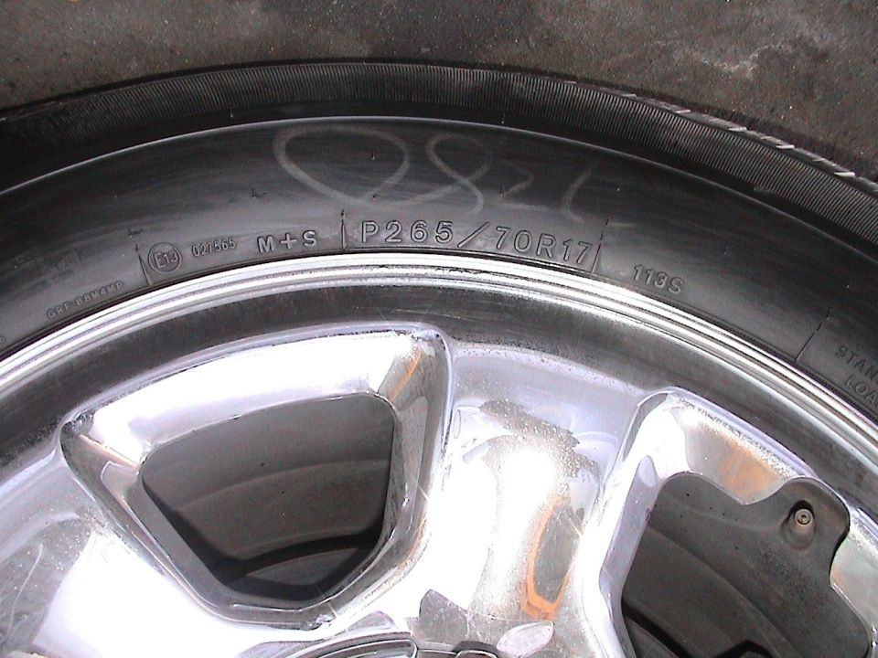 Tire sidewall reading M+S P265/70R17 113S on a chrome alloy wheel