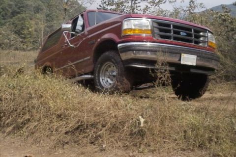 1994 Ford Bronco - This 1994 Ford Bronco is captured in a three-quarter front view while navigating rough terrain.