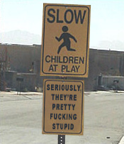 1991 Ford Bronco - A two-part sign warns drivers about children playing, with a humorous addition on the second panel.