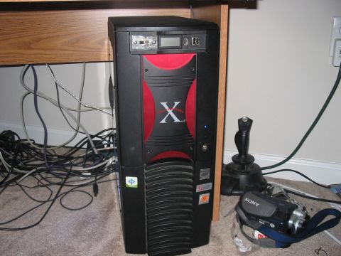 1988 Ford Bronco - A computer tower sits on the floor next to a joystick and a camcorder, with a tangle of wires behind it.