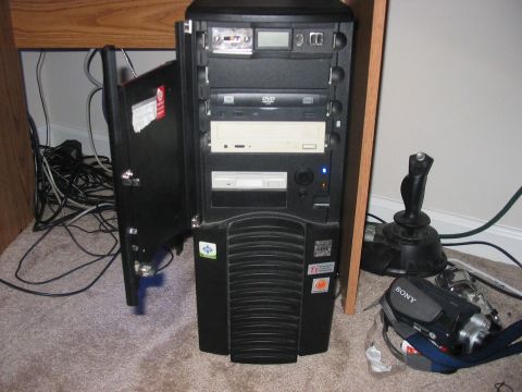 1988 Ford Bronco - A computer tower sits on a carpeted floor next to a wooden desk, with various peripherals attached.