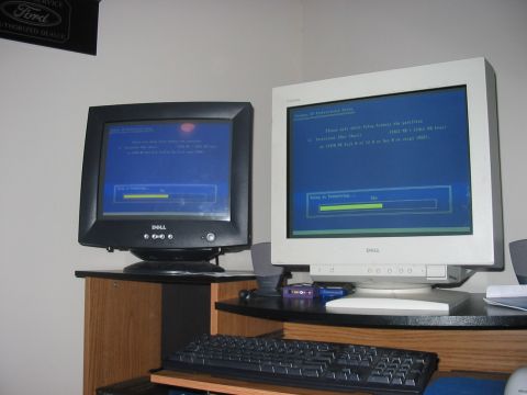 1988 Ford Bronco - Two computer monitors display installation progress, with a Ford Authorized Dealer sign visible on the wall.