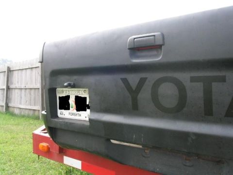 1986 Ford F-150 - The rear of a Toyota truck is visible, showing the tailgate and a license plate.