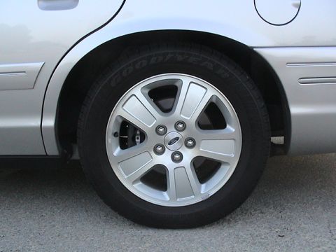 2004 Ford Crown Victoria - Close-up of the rear wheel and fender of a silver 2004 Ford Crown Victoria.