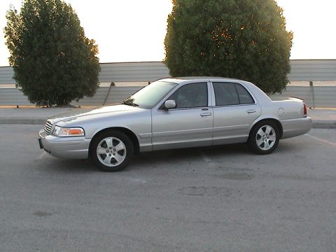 2004 Ford Crown Victoria - Side profile of a silver 2004 Ford Crown Victoria sedan parked outdoors.