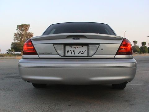 2004 Ford Crown Victoria - The rear of a silver sedan is shown, a spoiler and a license plate with Arabic text.