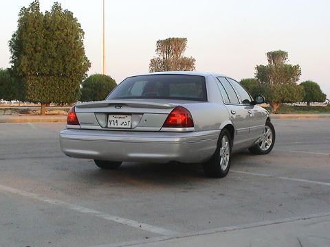 2004 Ford Crown Victoria - Rear view of a silver 2004 Ford Crown Victoria sedan parked in a lot.