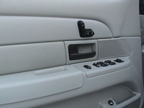 2004 Ford Crown Victoria - Close-up of a car's interior door panel, showing various electronic controls.