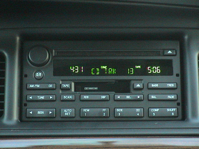 Dashboard radio with green digital display showing time and CD track information