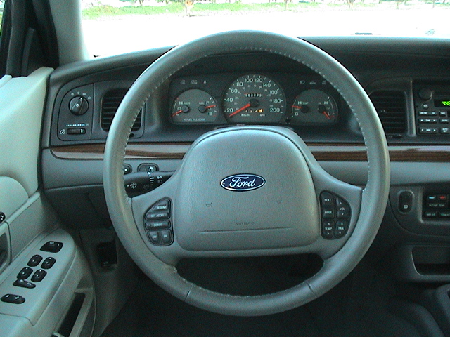 Interior dashboard of a 2004 Ford Crown Victoria showing the steering wheel and instrument cluster