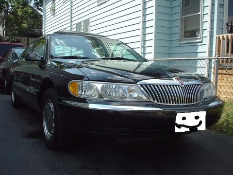 1997 Ford Crown Victoria - Front view of a black Lincoln Continental parked on a driveway.