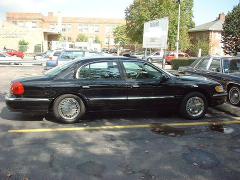 1997 Ford Crown Victoria - A black Lincoln Continental is parked in a lot next to another vehicle.