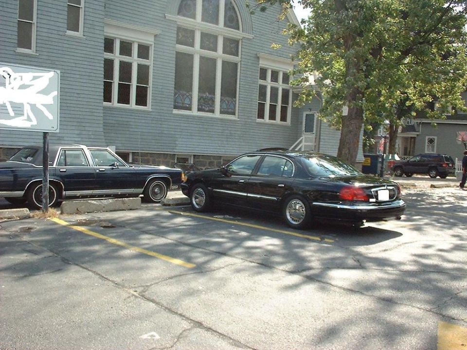 Black sedan, rear view. Likely a 1995 Lincoln Town Car