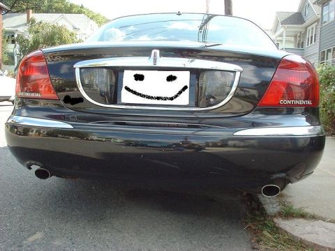 1997 Ford Crown Victoria - The rear of a black Lincoln Continental sedan is shown, with a smiley face obscuring the license plate.