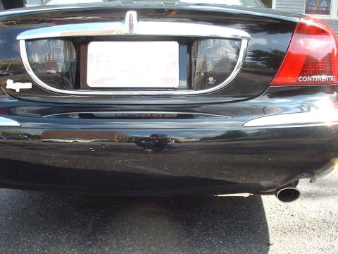 1997 Ford Crown Victoria - The rear of a black Lincoln Continental is shown, with the 'CONTINENTAL' script visible on the right taillight.