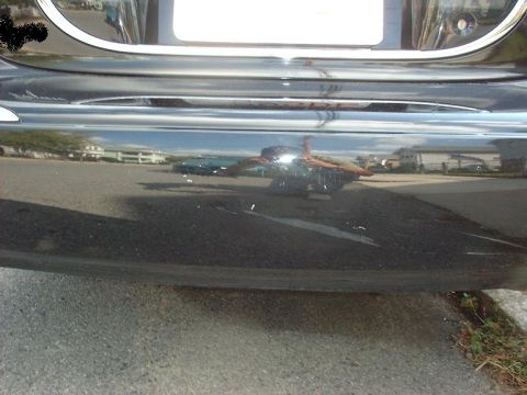 1997 Ford Crown Victoria - Reflection shows buildings and another vehicle behind the black car.