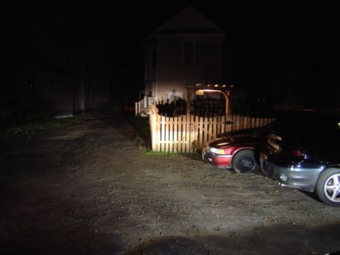 1998 Ford Taurus - Two vehicles are parked in a driveway at night, illuminated by artificial light.