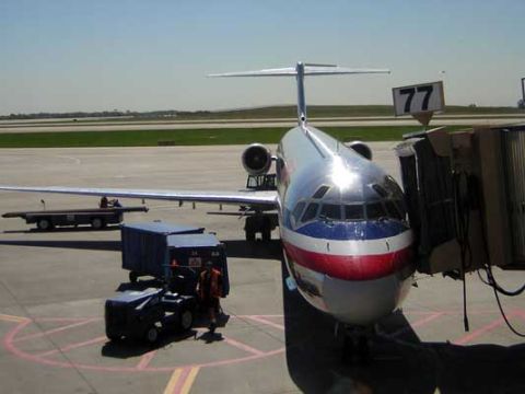 1995 Ford Bronco - Airplane at gate 77 with ground crew and equipment visible on the tarmac.
