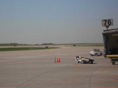 1995 Ford Bronco - Airport scene with various service vehicles and traffic cones on the tarmac under a clear sky.