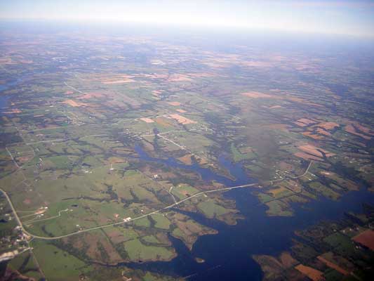 Aerial view of a rural landscape with a river, fields, and roads