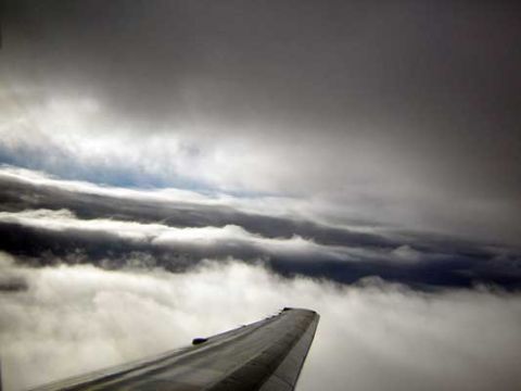 1995 Ford Bronco - View from an airplane window shows the wing cutting through layers of clouds.