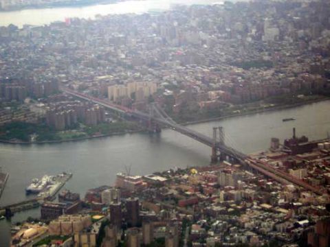 1995 Ford Bronco - An aerial perspective captures a urban landscape bisected by a wide river and a prominent suspension bridge.