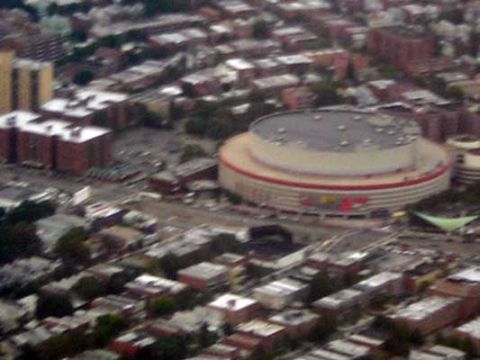 1995 Ford Bronco - An aerial perspective captures a urban landscape dominated by a large, circular stadium and dense residential blocks.