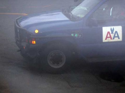 1995 Ford Bronco - Side view of a blue truck with an AA logo and a brush guard.