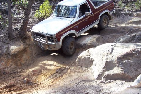 1982 Ford Bronco - This 1982 Ford Bronco is shown tackling a challenging off-road course with large rocks.