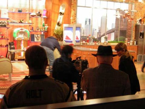1995 Ford Bronco - A film crew captures content within a studio, with a view of a city skyline and bridge through the window.