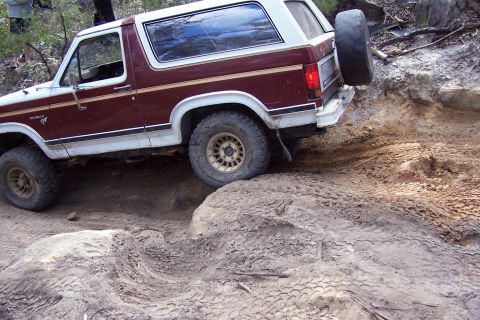 1982 Ford Bronco - Ford Bronco tackling a challenging off-road course with steep inclines and loose terrain.