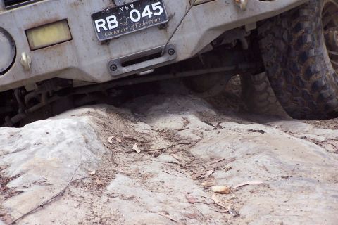 1982 Ford Bronco - This off-road vehicle navigates challenging rocky terrain, its front bumper and tire visible, with a NSW license plate reading RB 045.