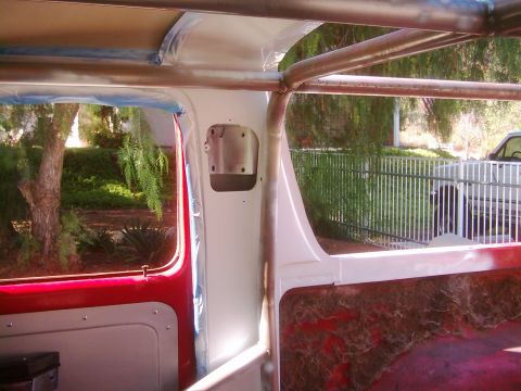 1978 Ford Bronco - The interior of a vehicle is being worked on, with a roll cage installed and some panels painted.