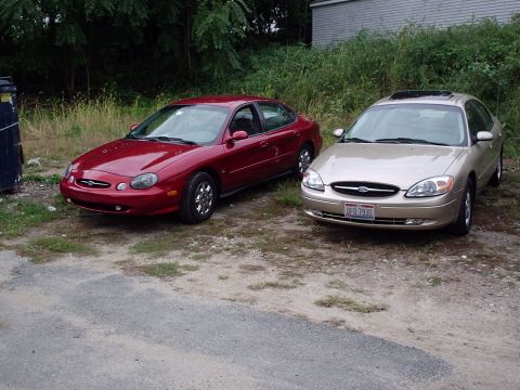 1998 Ford Taurus - Two Ford Taurus sedans are parked side-by-side in an outdoor lot.