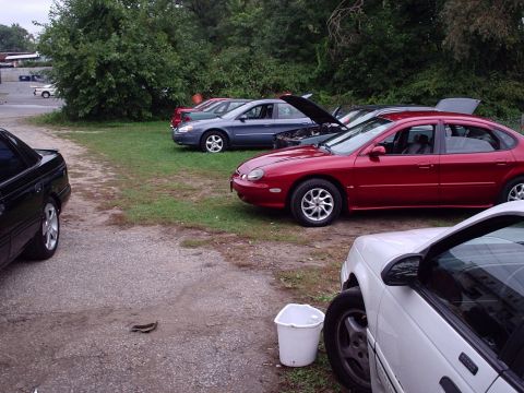 1998 Ford Taurus - Multiple sedans are parked in an outdoor lot with trees in the background.
