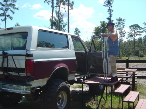 1993 Ford Bronco - A person on crutches uses custom-built steps to get into a lifted Ford Bronco.
