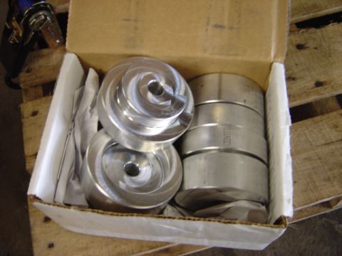 1998 Ford Taurus - Machined aluminum pump impellers are packed in a cardboard box on a wooden pallet.