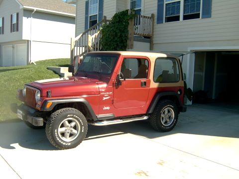 1998 Jeep TJ - This Jeep Wrangler is parked in a driveway in front of a suburban home.